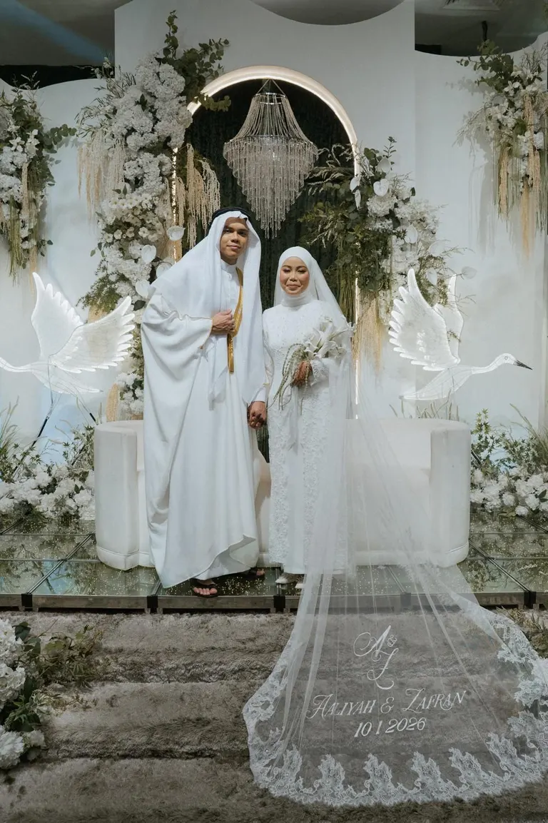 A couple with a cathedral veil embroidered with their names